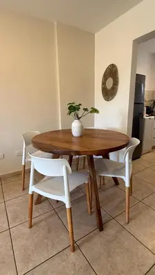 a wooden table and chairs with a potted plant on it at Güemes Apartamento in Cordoba