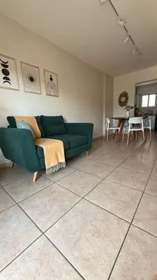 a living room with a green couch and a table at Güemes Apartamento in Cordoba