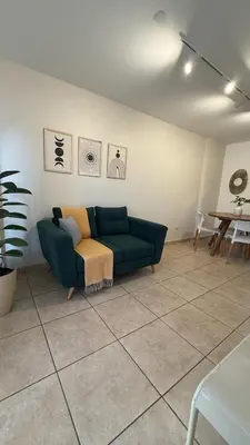 a living room with a green couch and a table at Güemes Apartamento in Cordoba