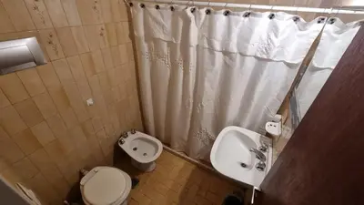 a bathroom with a toilet and a sink and a shower curtain at centro apartment in Cordoba