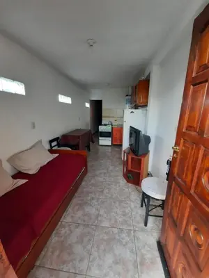 a bedroom with a bed and a living room at Marisa depto temporario in Villa Carlos Paz