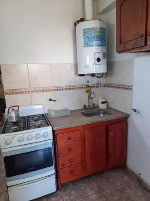 a small kitchen with a stove and a sink at Marisa depto temporario in Villa Carlos Paz