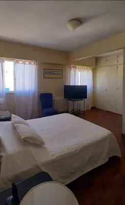 a bedroom with a large bed and a television at Amplio departamento céntrico con cochera in Río Cuarto