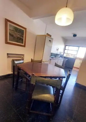 a kitchen with a wooden table and a refrigerator at Amplio departamento céntrico con cochera in Río Cuarto