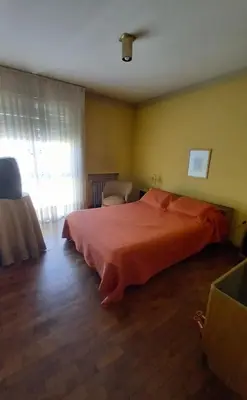 a bedroom with a large orange bed in a room at Amplio departamento céntrico con cochera in Río Cuarto