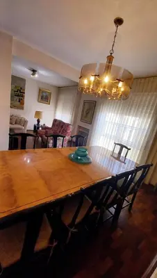 a wooden table in a living room with a dining room at Amplio departamento céntrico con cochera in Río Cuarto