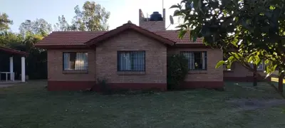 a small brick house with a tree in the yard at Posada Del Galés in Los Molles
