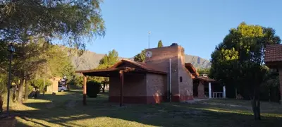 a small brick church with a mountain in the background at Posada Del Galés in Los Molles