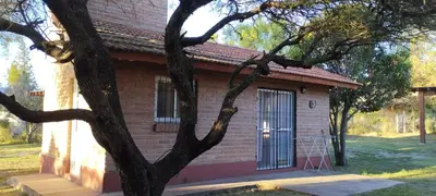 a small brick house with a tree in front of it at Posada Del Galés in Los Molles