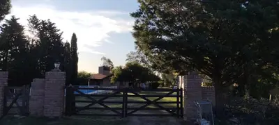 a fence with a wooden gate in a yard at Posada Del Galés in Los Molles