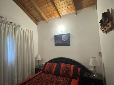 a bedroom with a bed and two lamps and a window at Dúplex Carlos Paz in Villa Carlos Paz