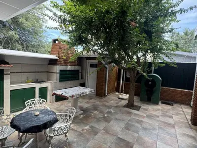 a patio with a table and chairs and a tree at Dúplex Carlos Paz in Villa Carlos Paz
