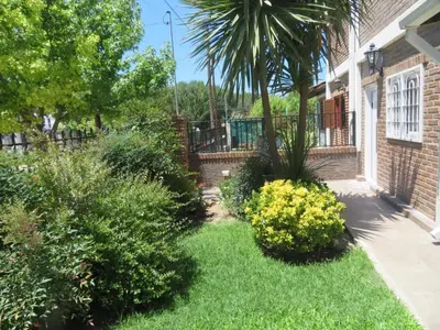 a yard with some bushes and a house at Dúplex Carlos Paz in Villa Carlos Paz
