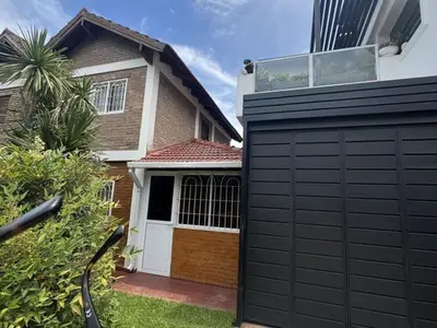 a house with a black garage and a building at Dúplex Carlos Paz in Villa Carlos Paz