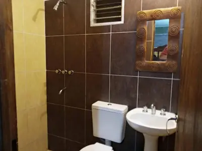 a bathroom with a toilet and a sink and a mirror at paprikas in Villa Ciudad Parque