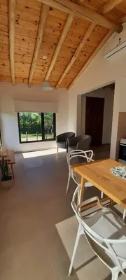 a living room with a wooden ceiling and a table and chairs at Casa de Campo Roca - Exclusivo para Parejas in Villa Cura Brochero