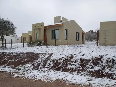 a house in a yard with snow on the ground at Casa de Campo Roca - Exclusivo para Parejas in Villa Cura Brochero