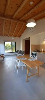 a living room with a wooden table and chairs at Casa de Campo Roca - Exclusivo para Parejas in Villa Cura Brochero
