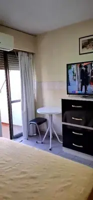 a room with a table and a tv and a bed at Departamento Balcarce 455 in Cordoba