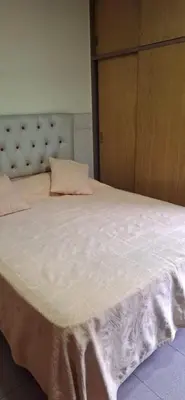 a bedroom with a large white bed with a wooden headboard at Departamento Balcarce 455 in Cordoba