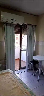 a room with a bed and a table and a window at Departamento Balcarce 455 in Cordoba