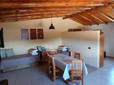 a room with a table and a couch and a bed at La Soñada in Villa Independencia