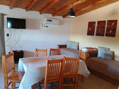 a dining room with a table and chairs and a couch at La Soñada in Villa Independencia
