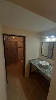 a bathroom with a sink and a counter with a mirror at Cabañas Piscu Yaco in Santa Rosa de Calamuchita