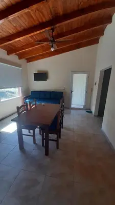 a living room with a table and a couch at Cabañas Piscu Yaco in Santa Rosa de Calamuchita