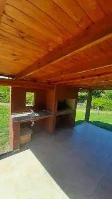 a covered patio with a wooden roof at Cabañas Piscu Yaco in Santa Rosa de Calamuchita