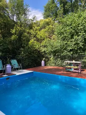 a blue swimming pool with a table and chairs at Siempre verde in El Rincón