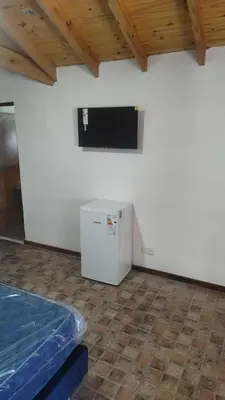 a room with a white refrigerator and a flat screen tv at Gran aldea in Mina Clavero