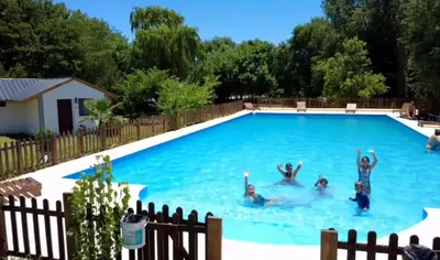 a group of people swimming in a swimming pool at Gran aldea in Mina Clavero