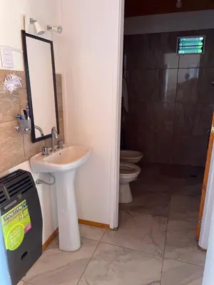 a bathroom with a sink and a toilet and a mirror at La soñada AG in Alta Gracia