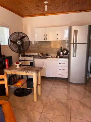 a kitchen with a refrigerator and a table with a fan at La soñada AG in Alta Gracia
