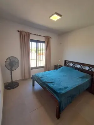 a bedroom with a bed and a fan and a window at Mis tres estrellas 2 in Cavalango
