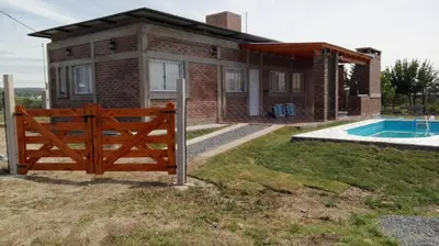 a house with a wooden fence and a swimming pool at Mis tres estrellas 2 in Cavalango