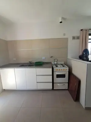 a kitchen with a stove and white cabinets at Mis tres estrellas 2 in Cavalango