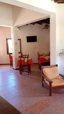 a room with tables and chairs and a flat screen tv at Hostería Sueños Dorados in Merlo