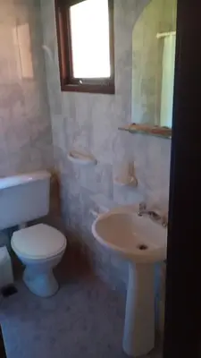 a bathroom with a white toilet and a sink at Hostería Sueños Dorados in Merlo