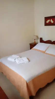 a bedroom with a bed with two towels on it at Hostería Sueños Dorados in Merlo