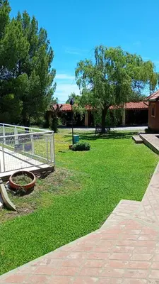 a park with a fence and green grass and trees at Hostería Sueños Dorados in Merlo