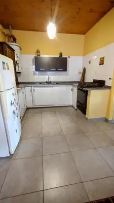 a kitchen with white cabinets and a white refrigerator at Casa de Ceci in Villa Carlos Paz