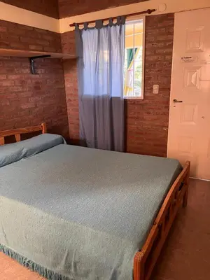 a bedroom with a bed and a window at El Pino Departamentos in Villa Cura Brochero
