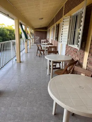 a patio with tables and chairs on a balcony at El Pino Departamentos in Villa Cura Brochero