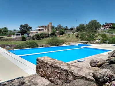 a large swimming pool with blue water in a resort at Casa Mabel in La Porteña