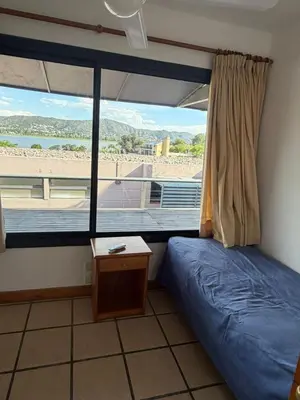 a bedroom with a bed and a window with a view of a beach at Casa Mabel in La Porteña