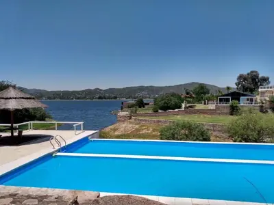 a swimming pool next to a body of water at Casa Mabel in La Porteña