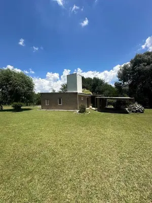 a building with a tower on top of a grass field at Mi lugar Potrero de Garay in La Estancia