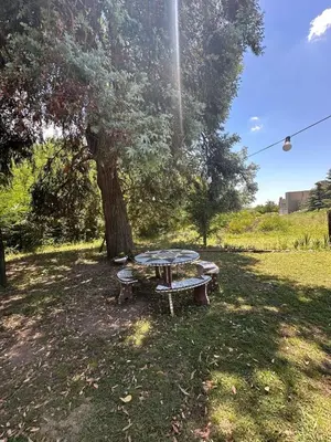 a picnic table under a tree in a park at Mi lugar Potrero de Garay in La Estancia